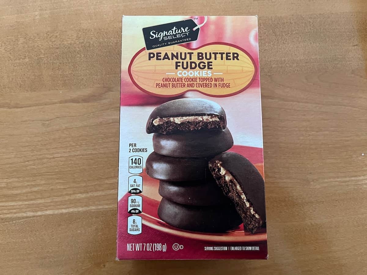 A box of generic girl scout peanut butter fudge cookies on a wooden surface.